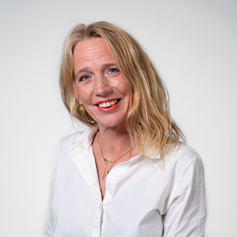 Portretfoto van Karin. Blonde vrouw met een witte blouse aan.